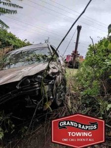 Wrecker pulling out car from culvert